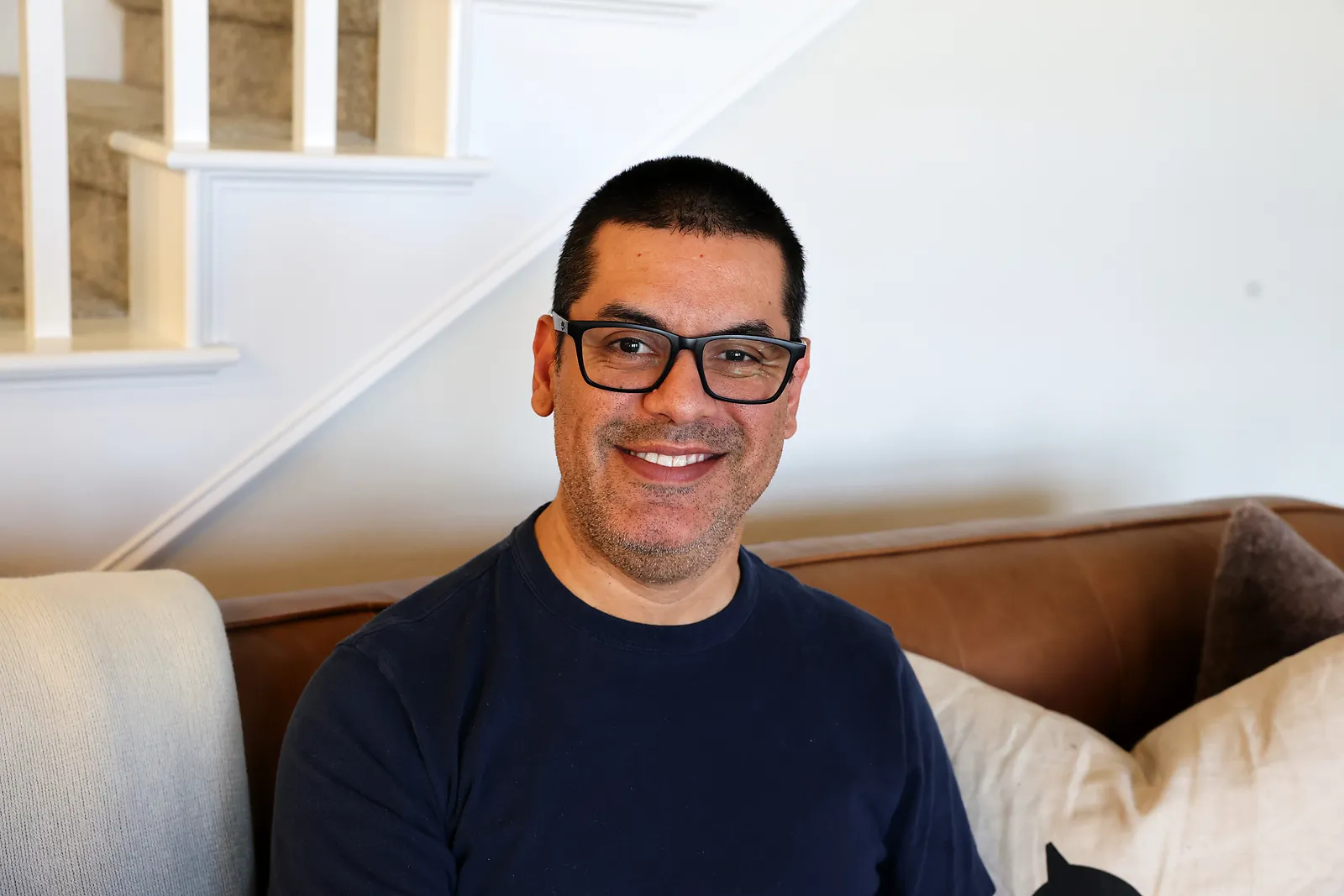 David Semprun smiling on a sofa at home